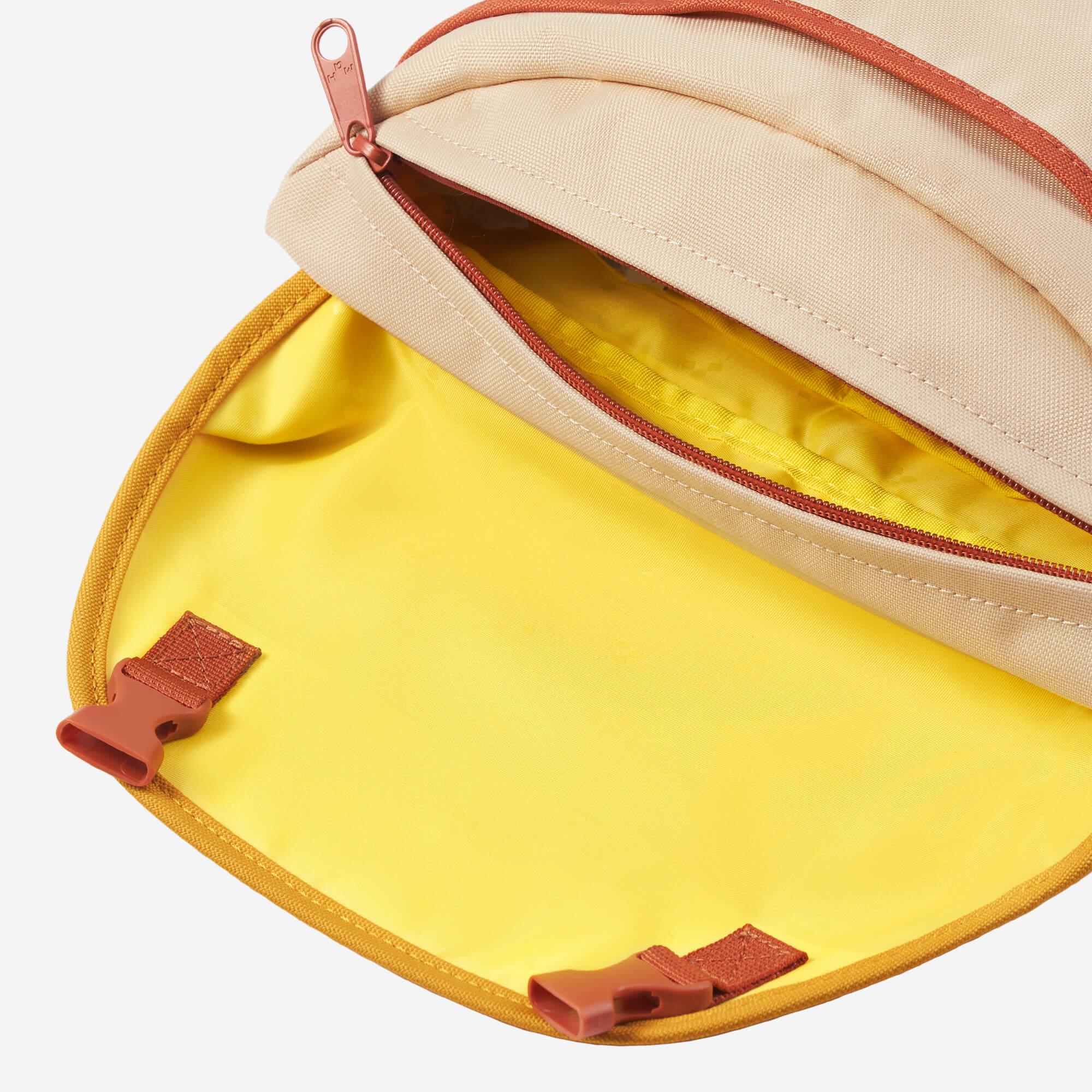 Beige backpack with yellow interior and orange zipper, showing organized compartments and buckles