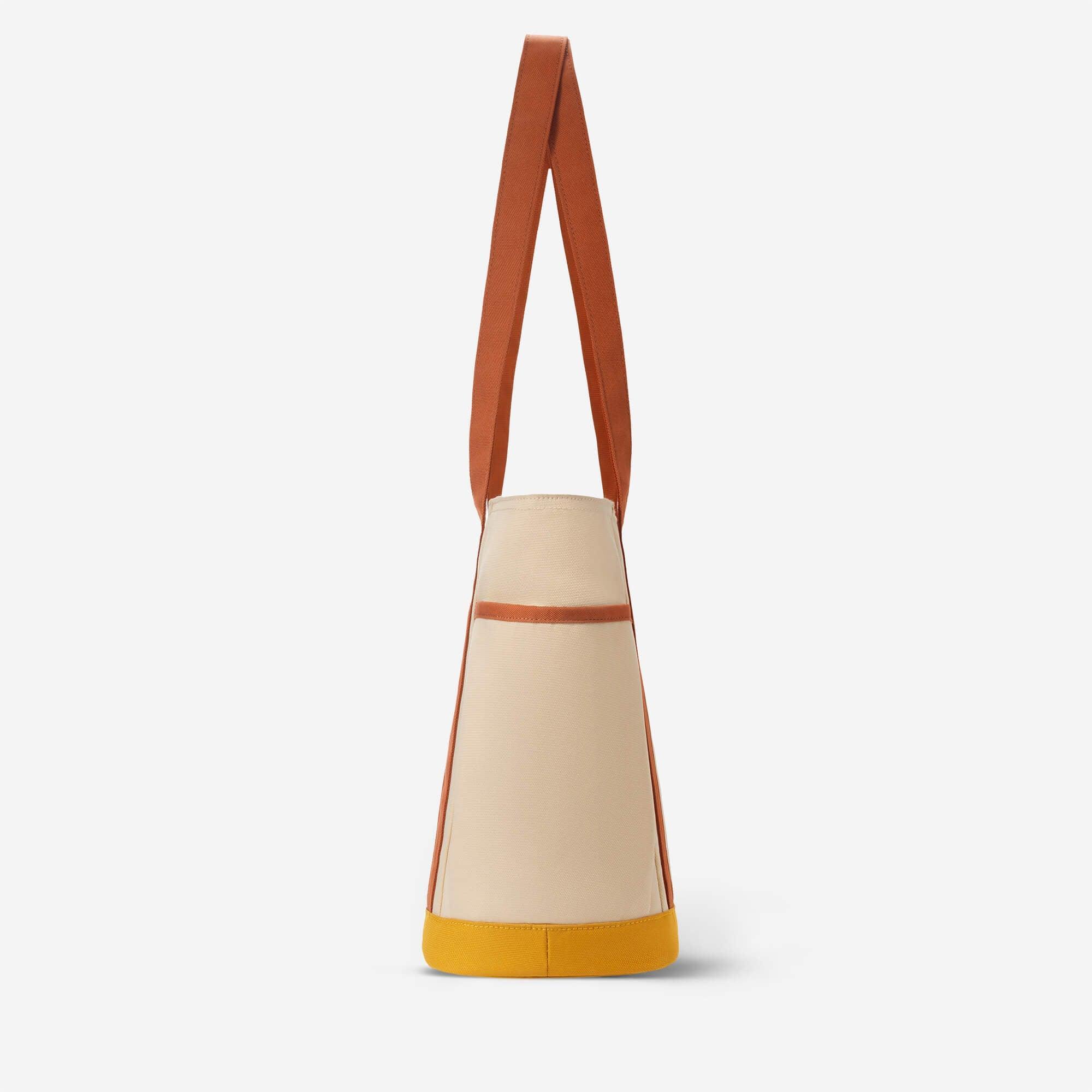Beige canvas tote bag with brown straps and yellow base, minimalist design for everyday use
