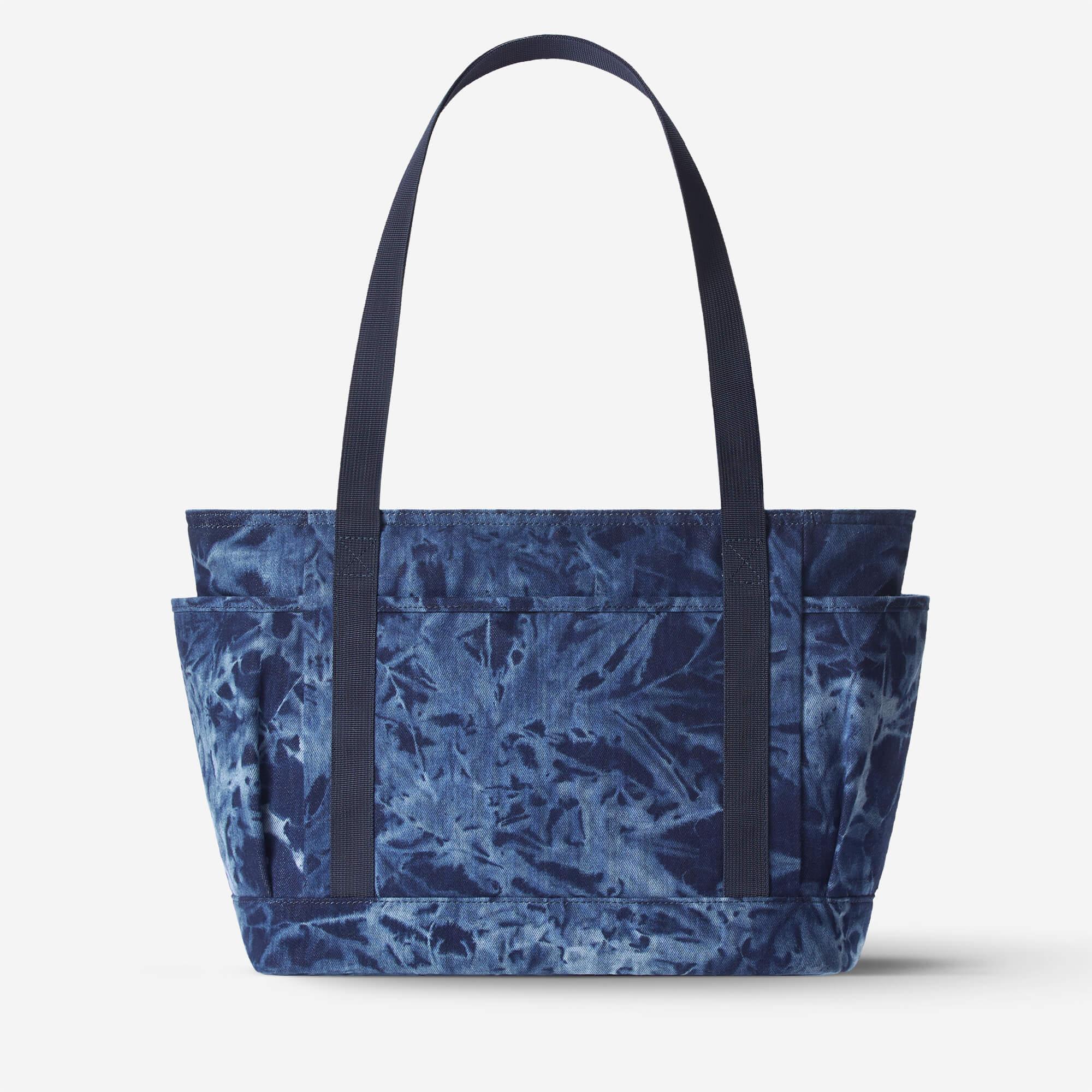 Blue tie-dye tote bag with side pockets and sturdy handles, ideal for everyday carry and lifestyle use.