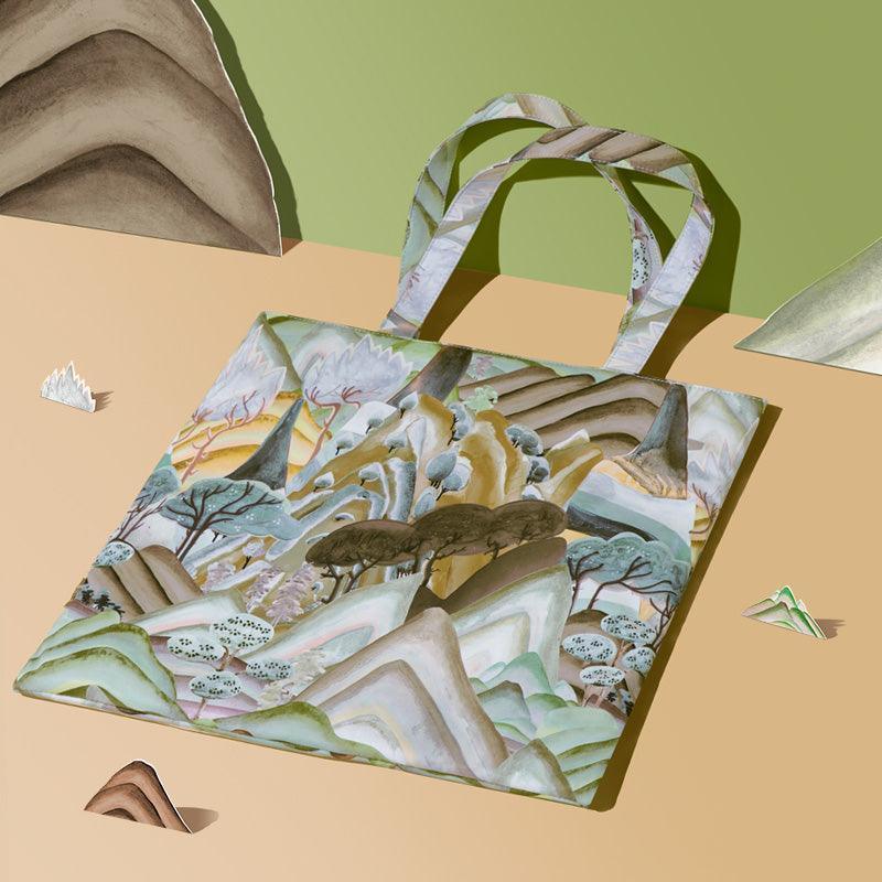 Artistic tote bag with mountain landscape print, ideal for eco-friendly shopping or daily use.