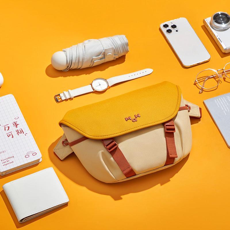 Stylish yellow and beige crossbody bag with red straps, perfect for everyday carry with phone, wallet, and accessories.